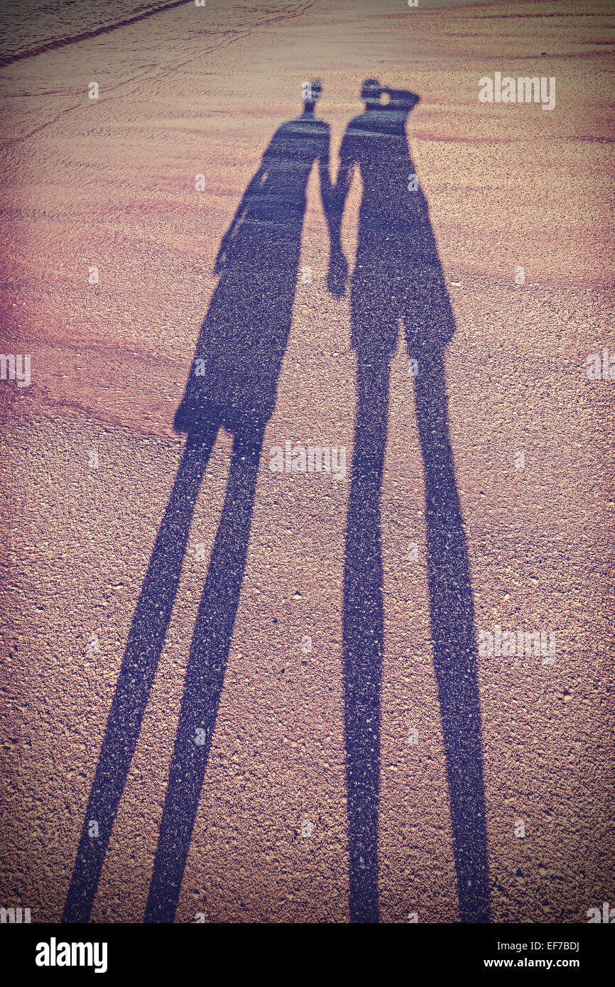 Vintage stylized picture of couple's shadow on beach. Stock Photo
