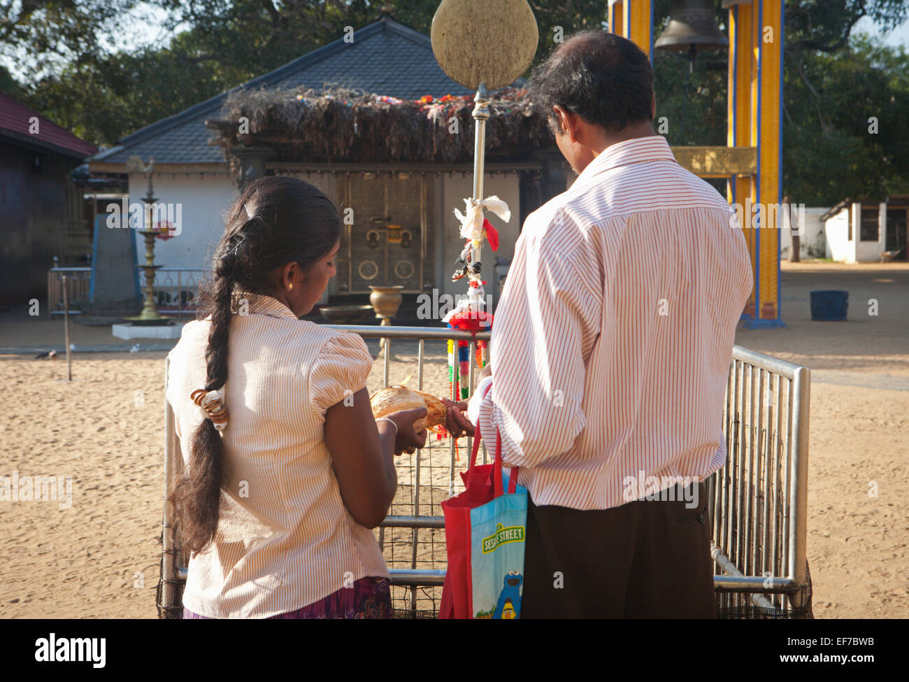 COUPLE DURING PRAYER AND GIVING OFFERING AT KATARAGAMA Stock Photo