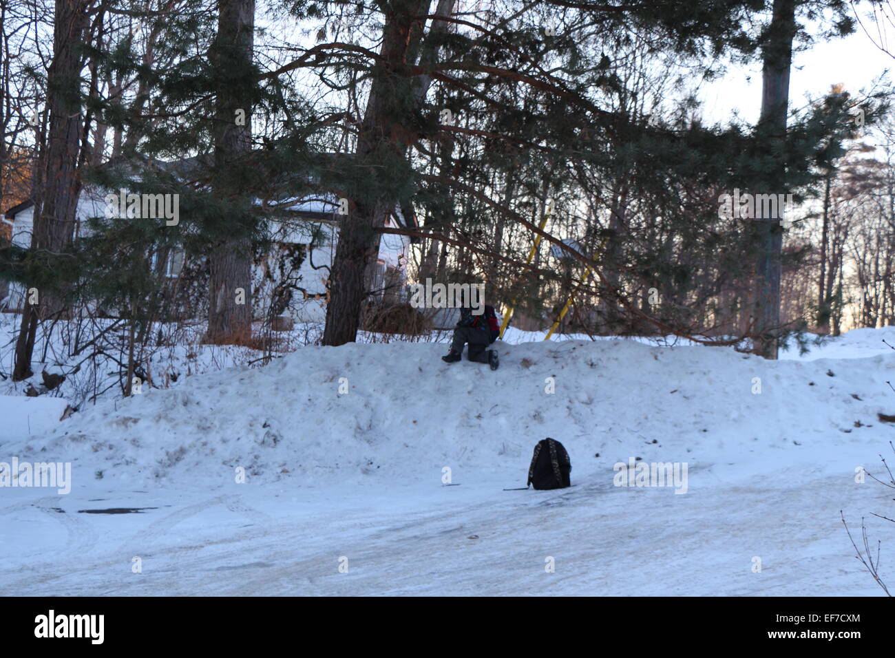 child playing in snow, at the to of hill Stock Photo