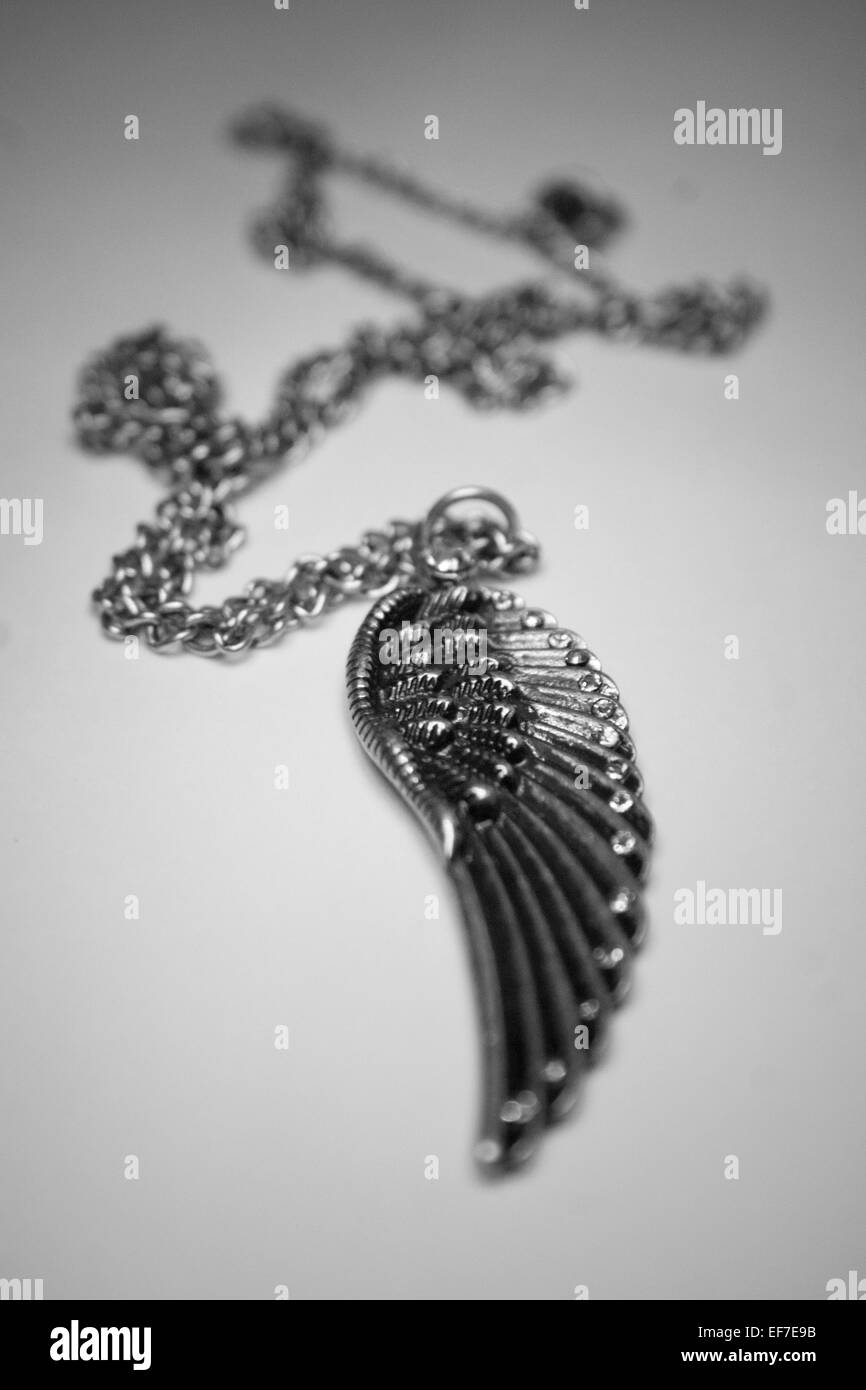 a Pewter colored angel wing necklace in black and white Stock Photo