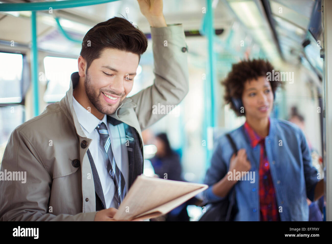 Businessman reading newspaper on train Stock Photo