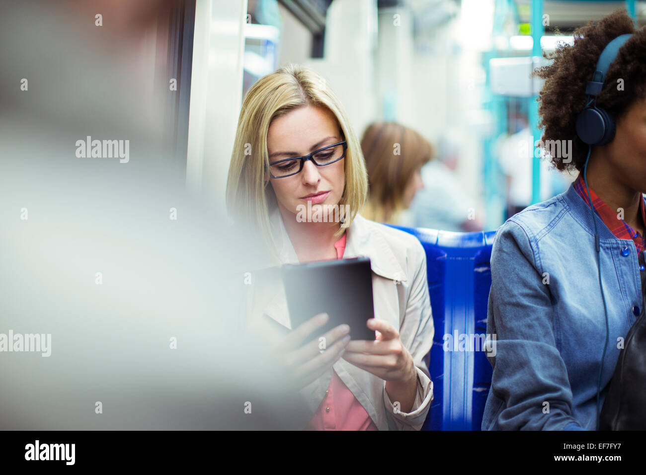 Businesswoman using digital tablet on train Stock Photo