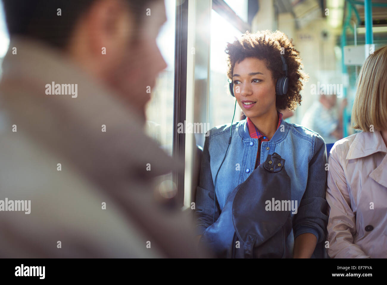 Woman listening to headphones on train Stock Photo