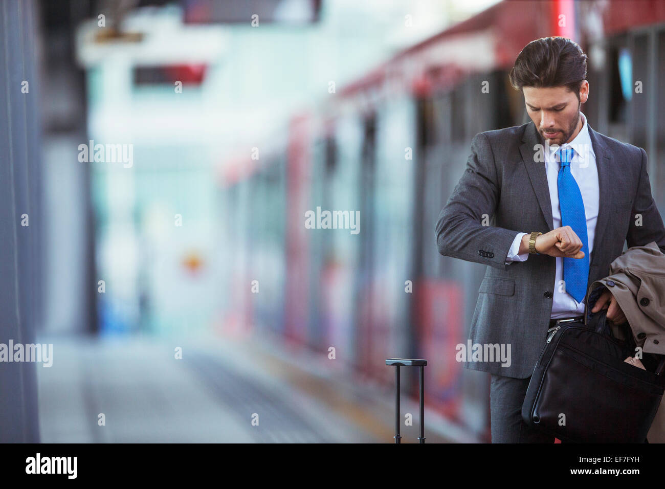 Businessman checking his watch in train station Stock Photo