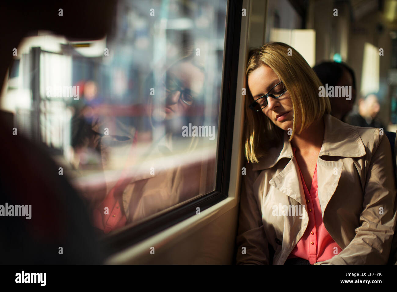 Businesswoman napping on train Stock Photo