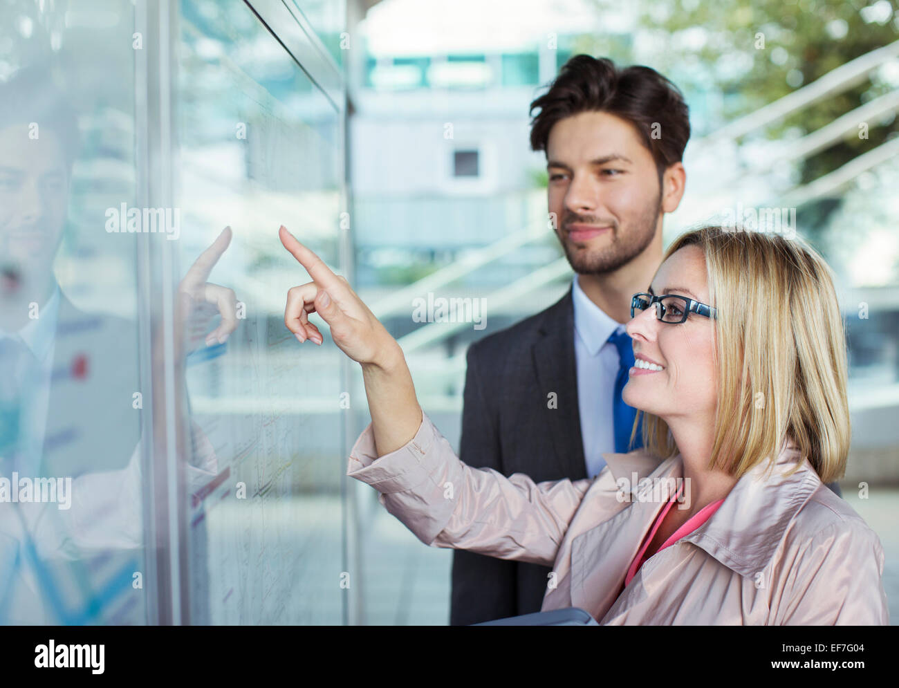 Business people reading transportation schedule Stock Photo