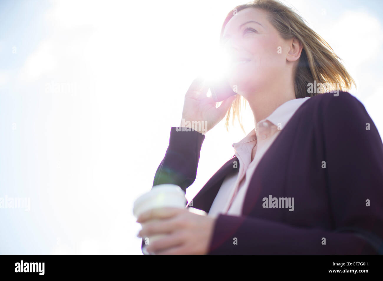 Low angle view of businesswoman talking on cell phone Stock Photo
