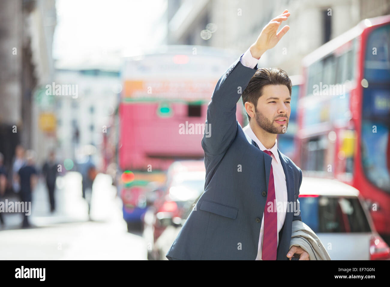 Businessman hailing taxi in city Stock Photo