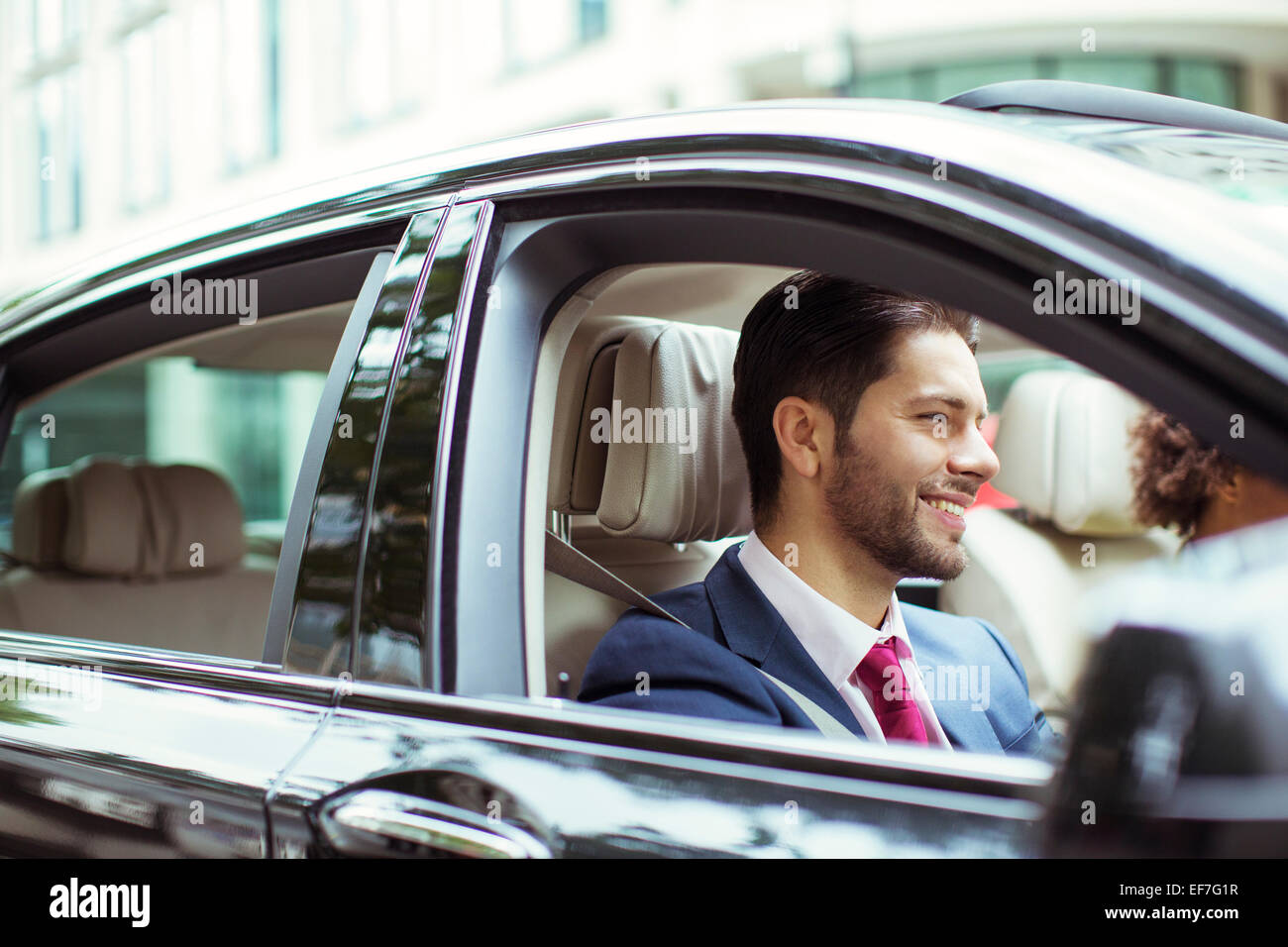 Businessman smiling in car Stock Photo