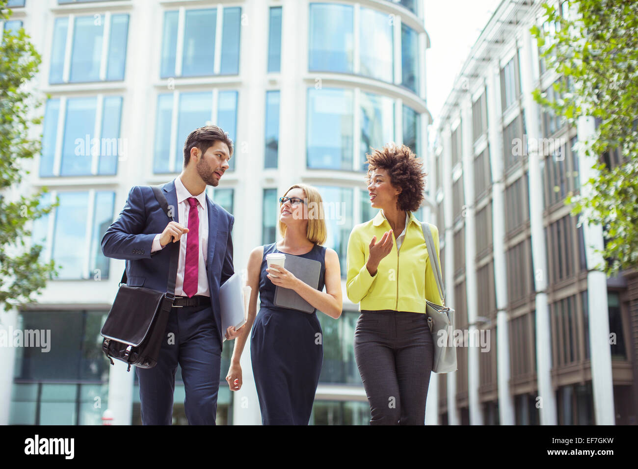 Business people walking and talking outdoors Stock Photo