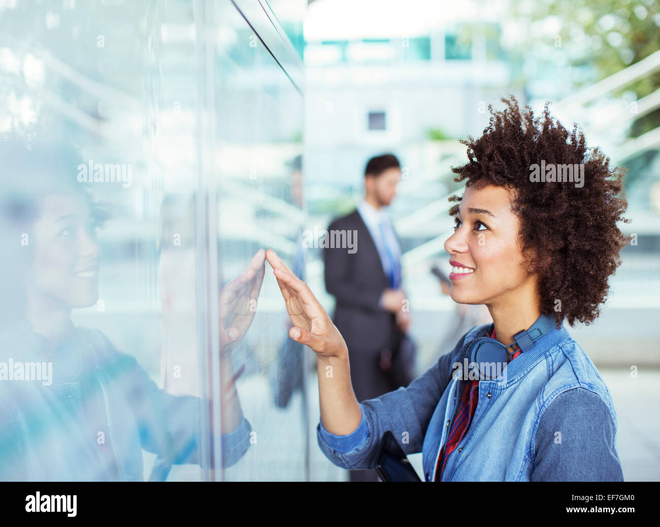 Woman reading transportation schedule at station Stock Photo