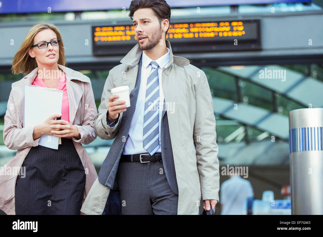 Business people walking and talking in train station Stock Photo