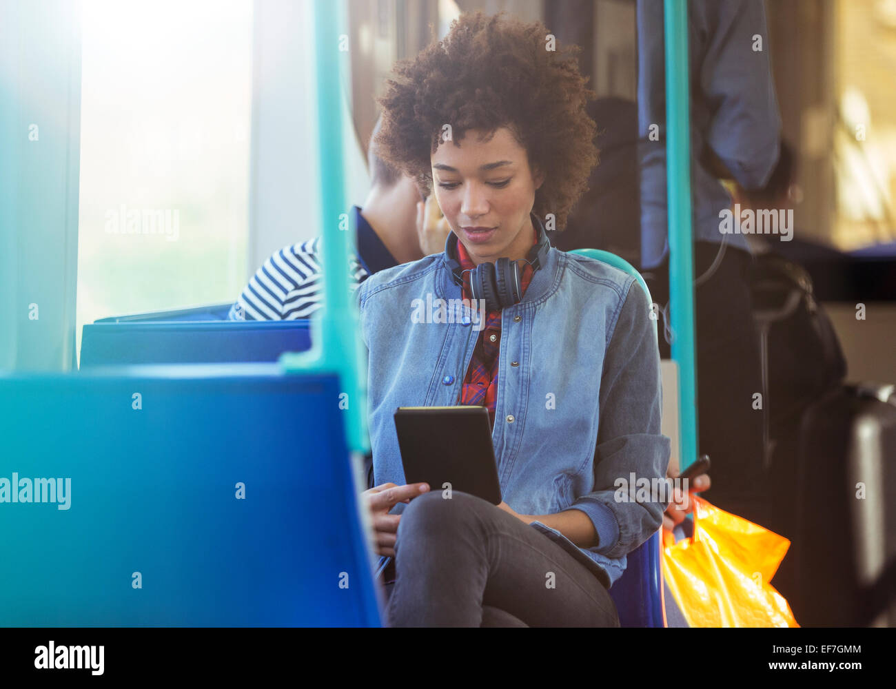 Woman using digital tablet on train Stock Photo