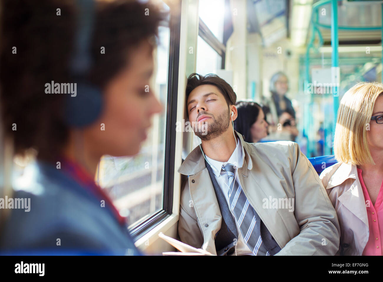 Businessman napping on train Stock Photo