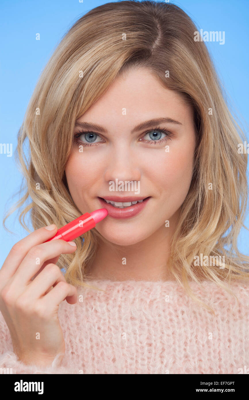 Woman applying lipstick on her lips Stock Photo