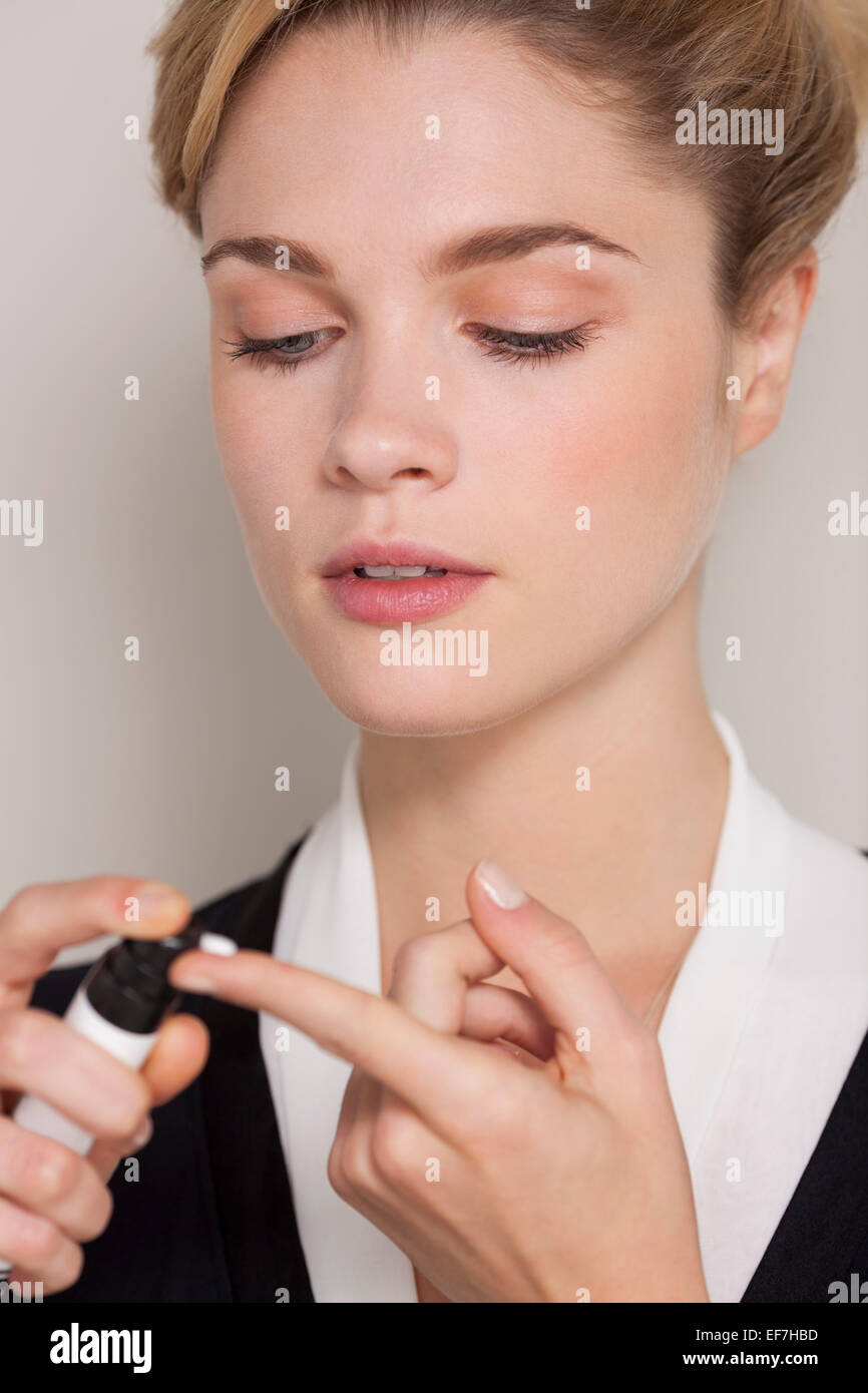 Woman squirting moisturizer on her finger Stock Photo