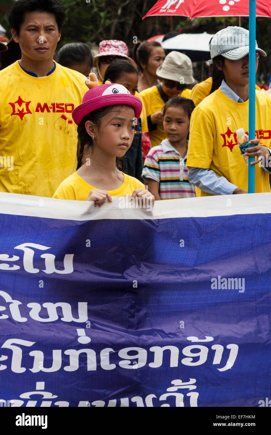 A little girl takes part in Lao New Year celebration parade on Luang Prabang street - Laos,  Asia. Stock Photo