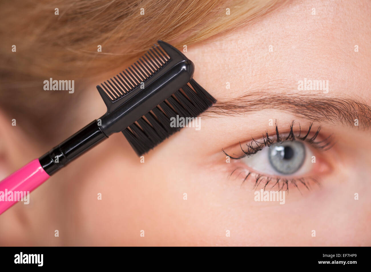 Beautiful woman brushing her eyebrow Stock Photo