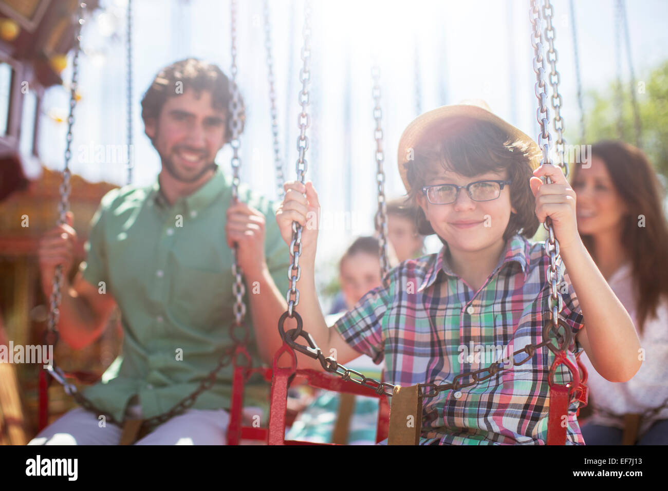 Boy smiling on carousel in amusement park Stock Photo - Alamy