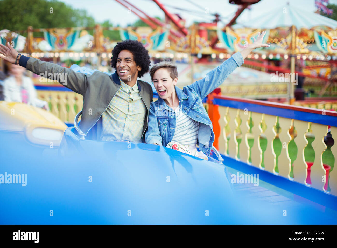 Cheerful couple on carousel in amusement park Stock Photo