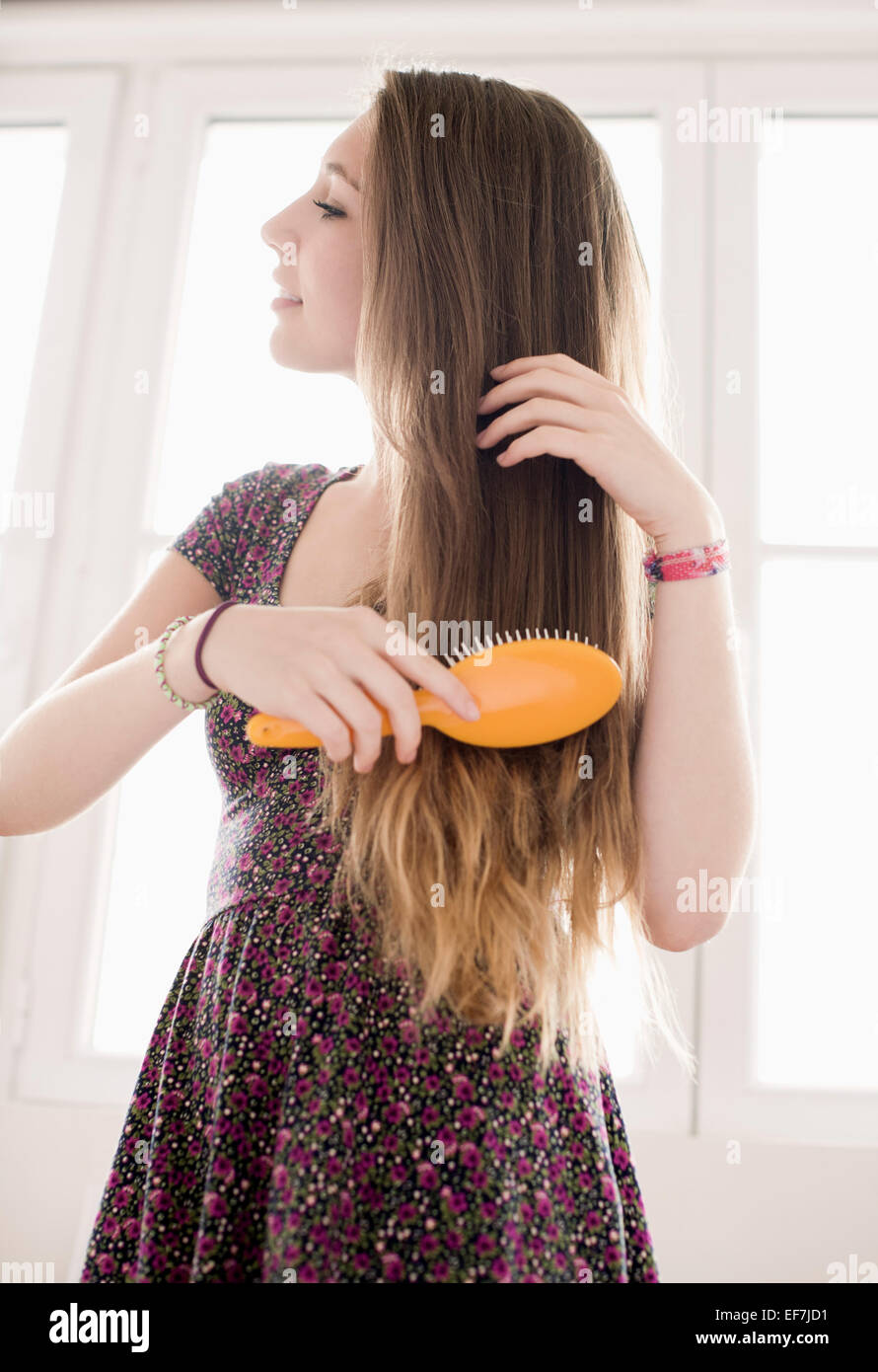 Teenage girl getting hair care with brush Stock Photo