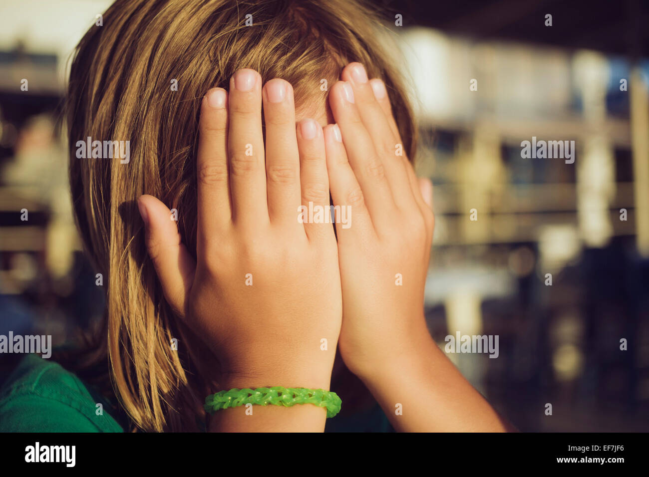 Boy hiding face with hands Stock Photo