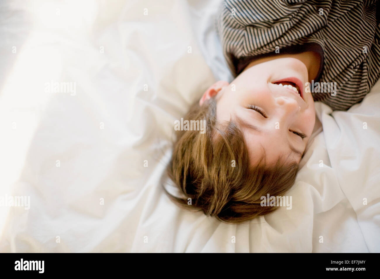 Happy boy lying on the bed Stock Photo