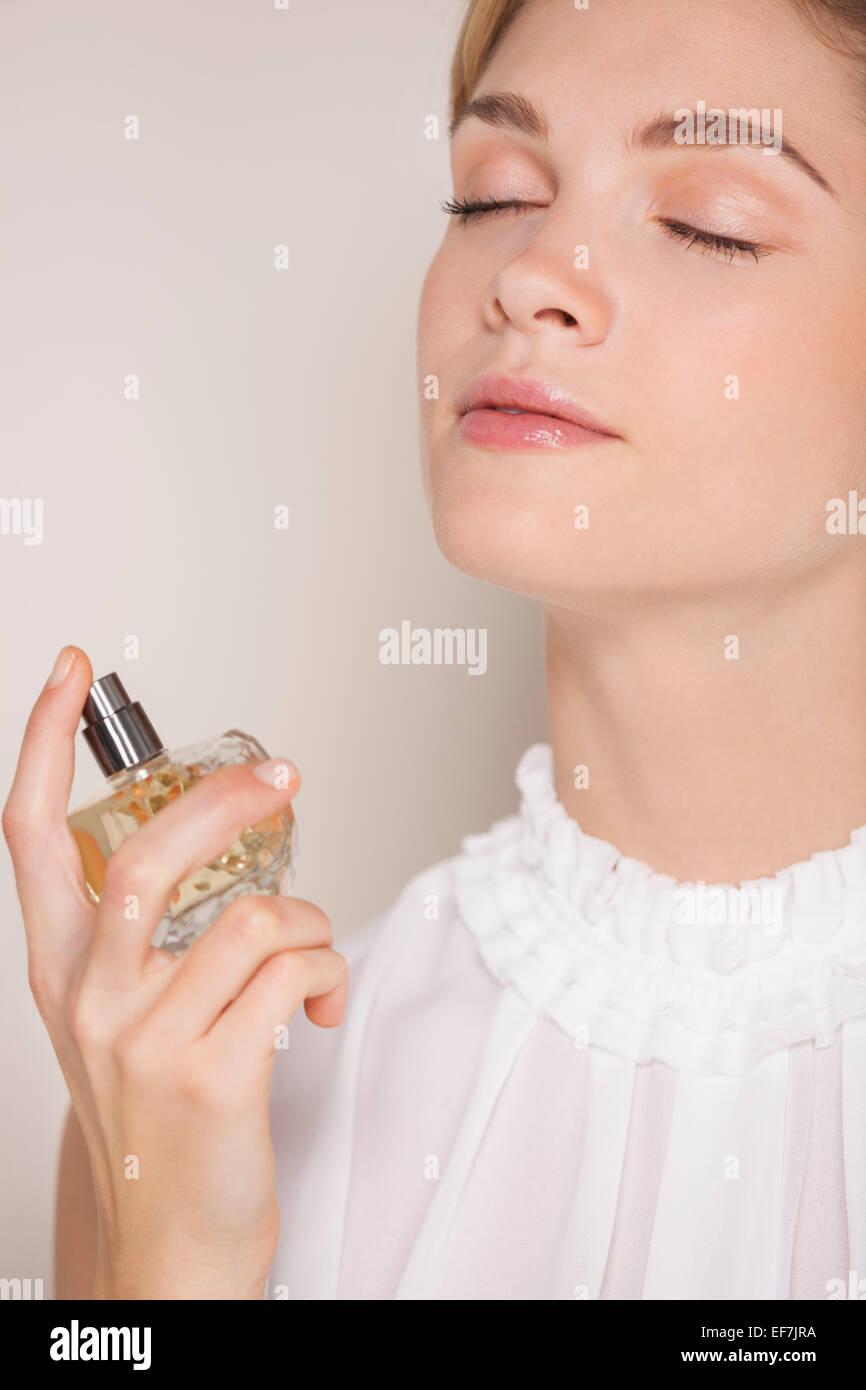 Beautiful woman applying perfume Stock Photo