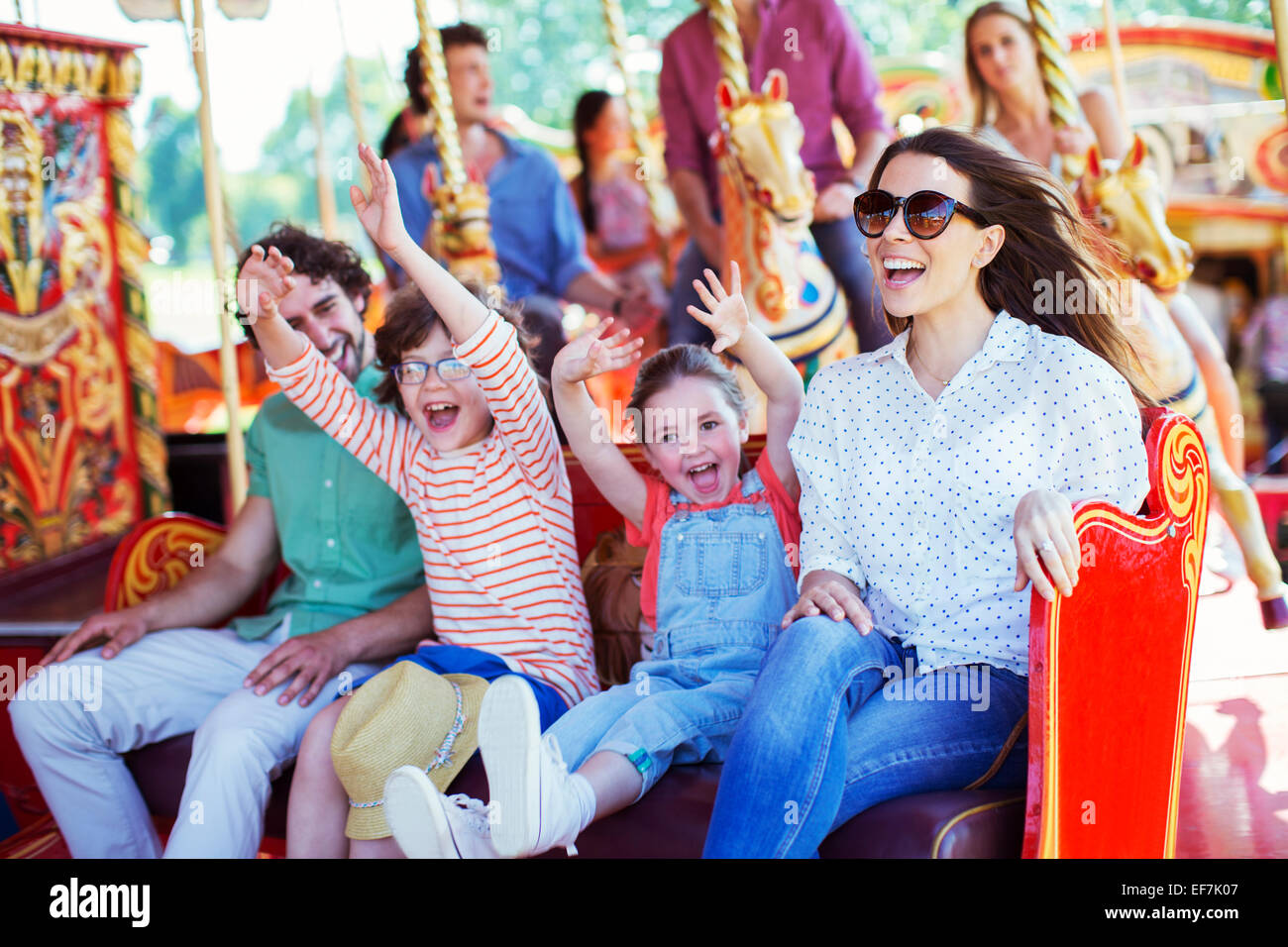Family on carousel in amusement park Stock Photo