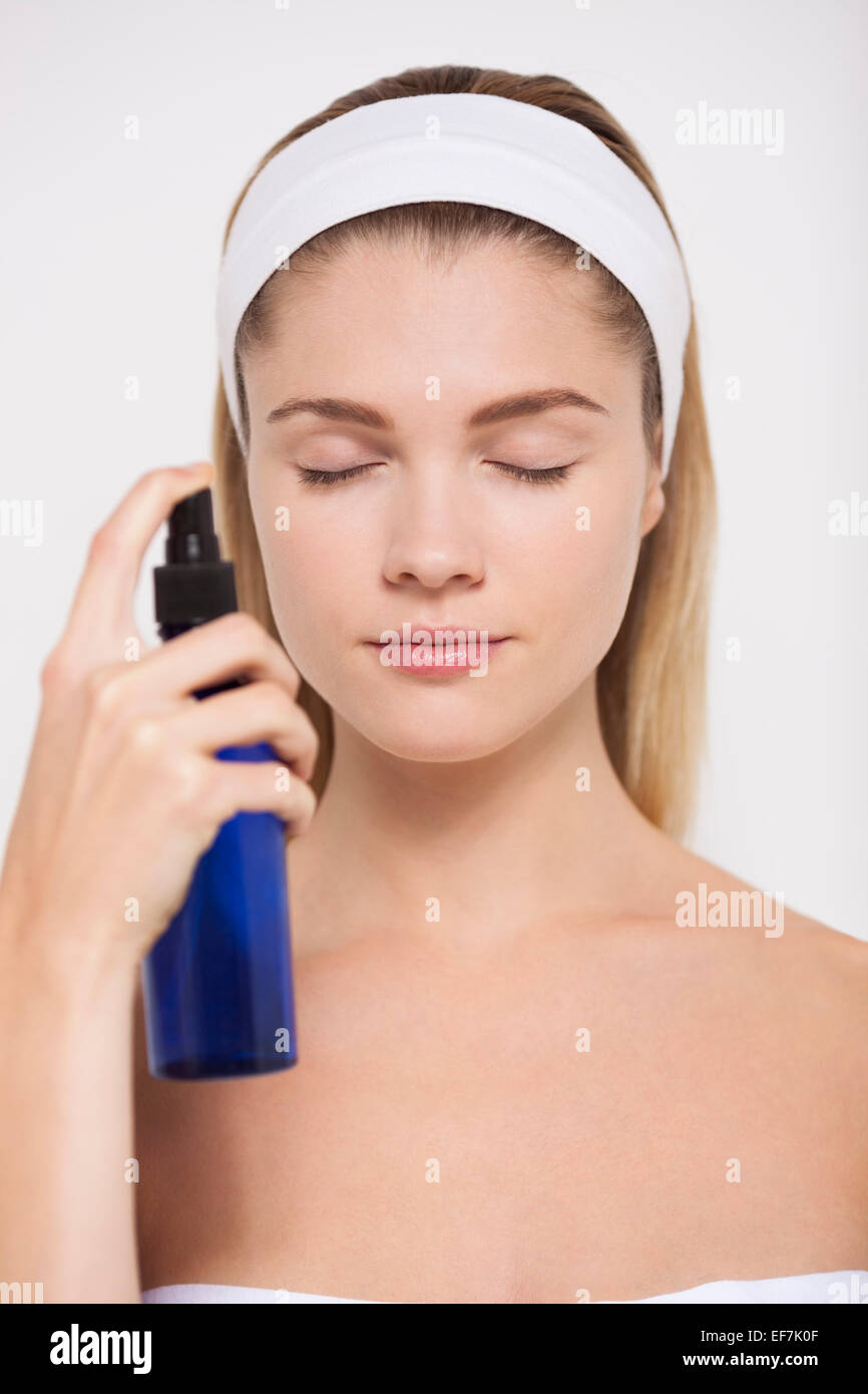 Beautiful woman spraying water on her face Stock Photo
