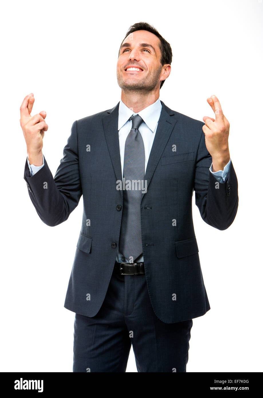 Half length portrait of a businessman smiling, looking above with his fingers crossed Stock Photo