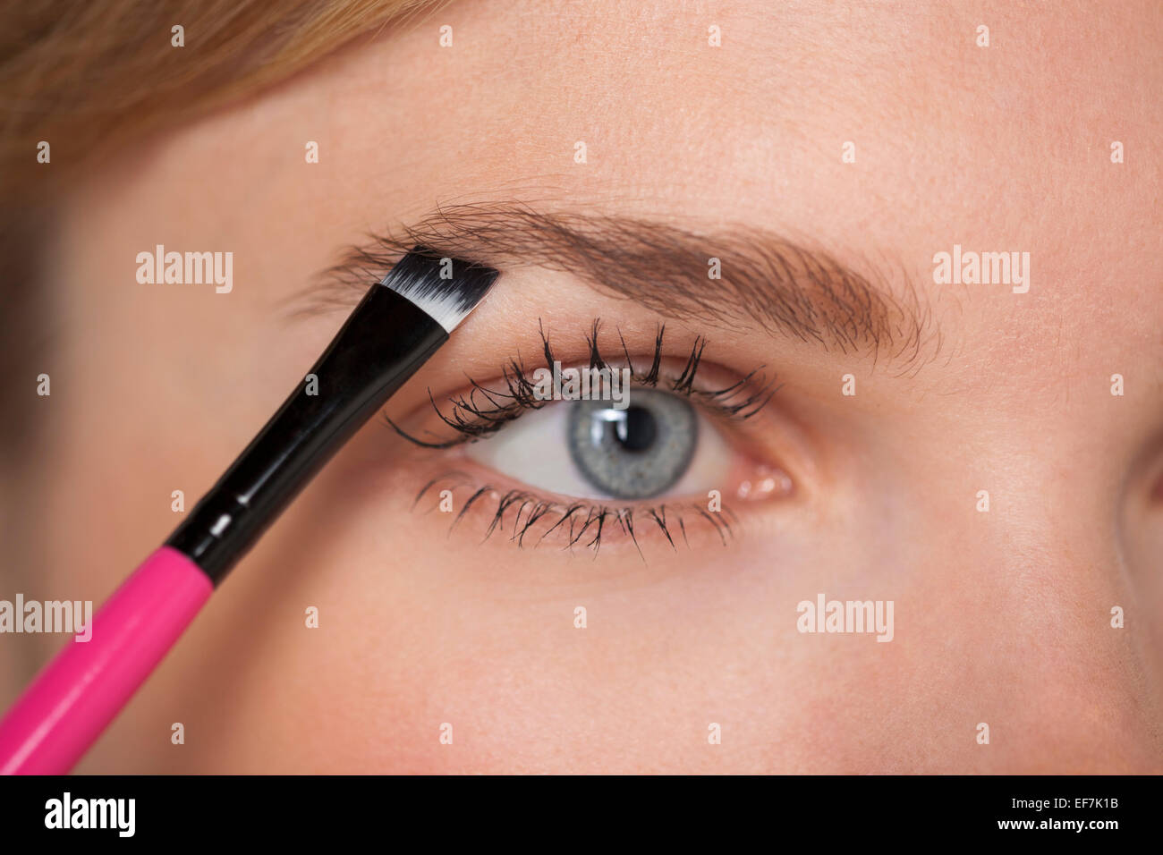 Beautiful woman brushing eyebrow Stock Photo