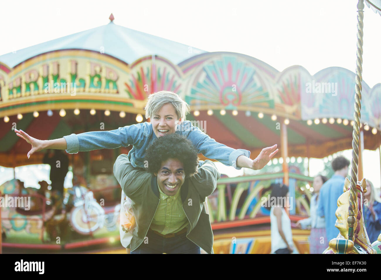 Portrait of young multiracial couple having fun in amusement park Stock Photo