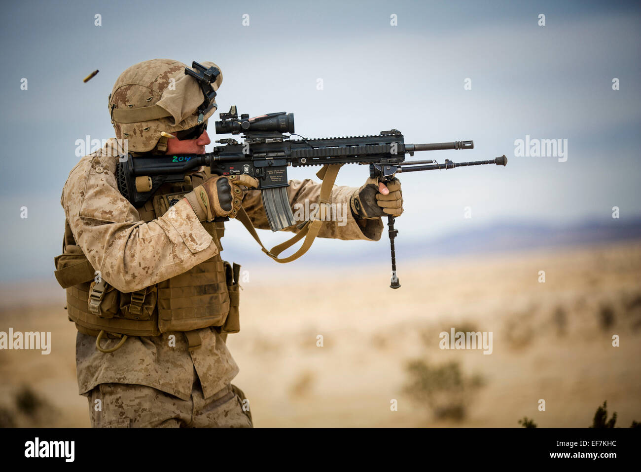 A US Navy corpsman fires the M-27 Infantry Automatic Rifle during live fire training at Camp Wilson January 20, 2015 in Twentynine Palms, California. Stock Photo