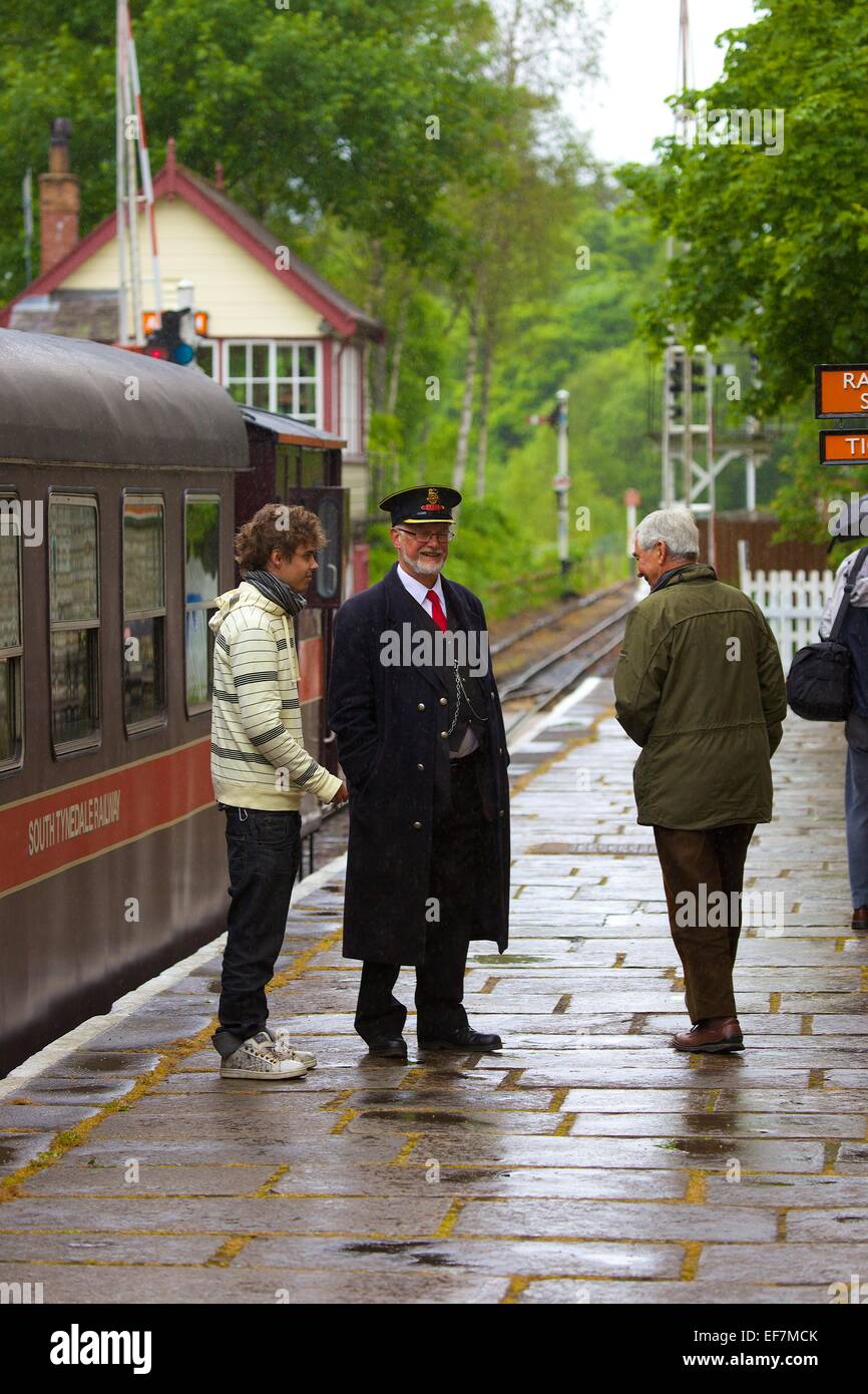 Passengers talking to station master South Tynedale Railway, Alston Station, Alston, Cumbria, England, UK. Stock Photo