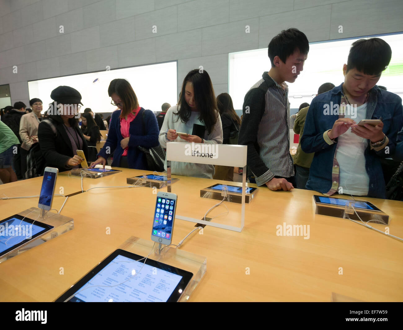 Costumers browsing Apple iPhones at the Apple store located on Nanjing Road in Shanghai, China Stock Photo