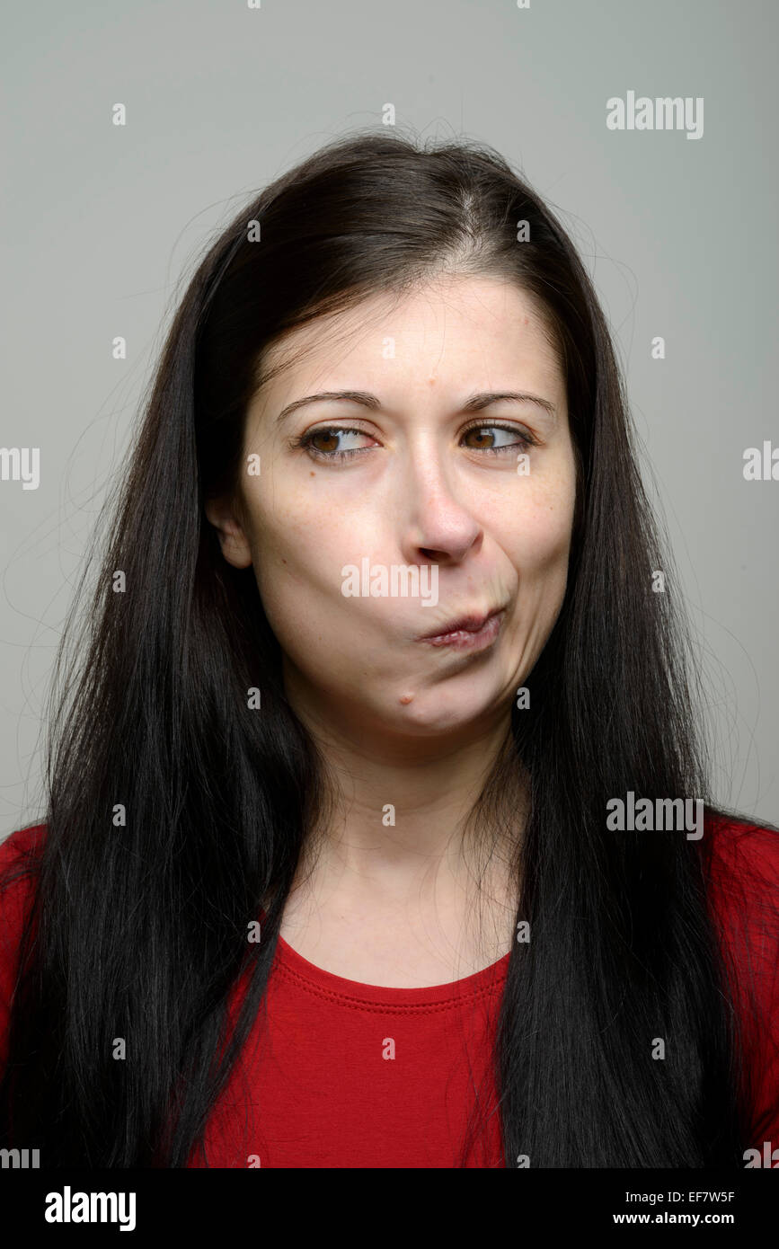 Angry young woman grimacing and looking to the side not impressed Stock Photo