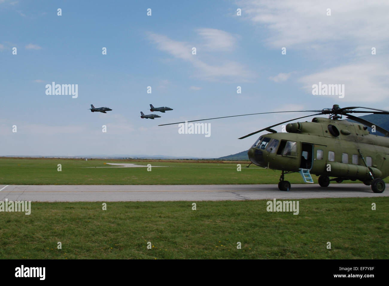 Group of military aircraft in flight over the helicopter in the air show. Stock Photo