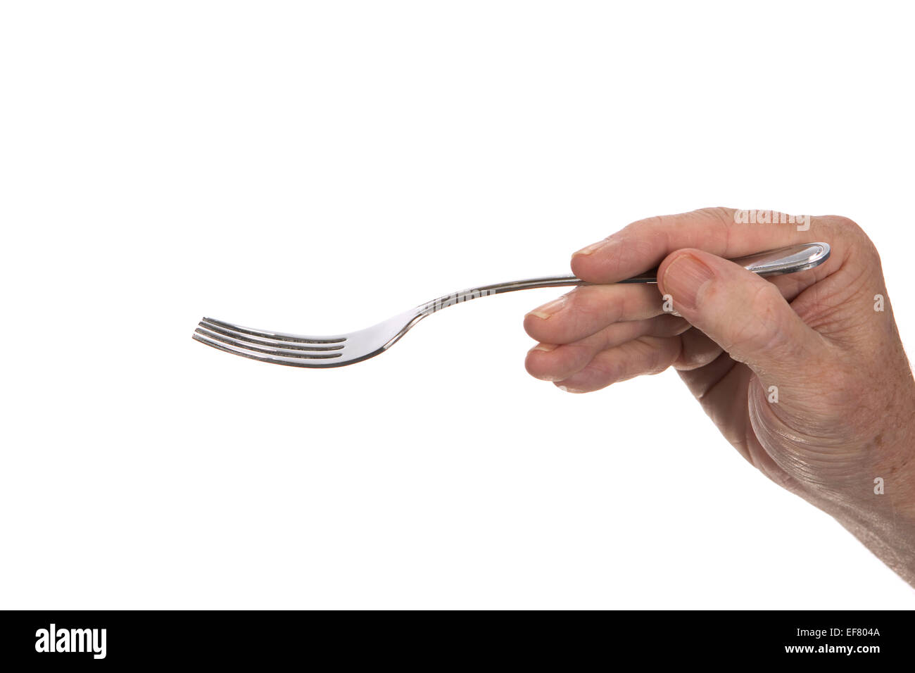 Man's hand ready to eat is holding a stainless steel dinner fork. Stock Photo