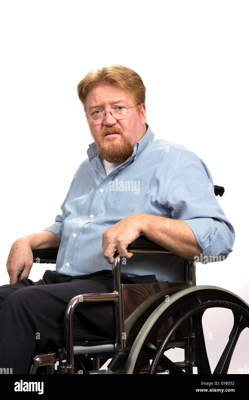 Disabled man sitting in a wheelchair poses with a serious expression on his face. Stock Photo