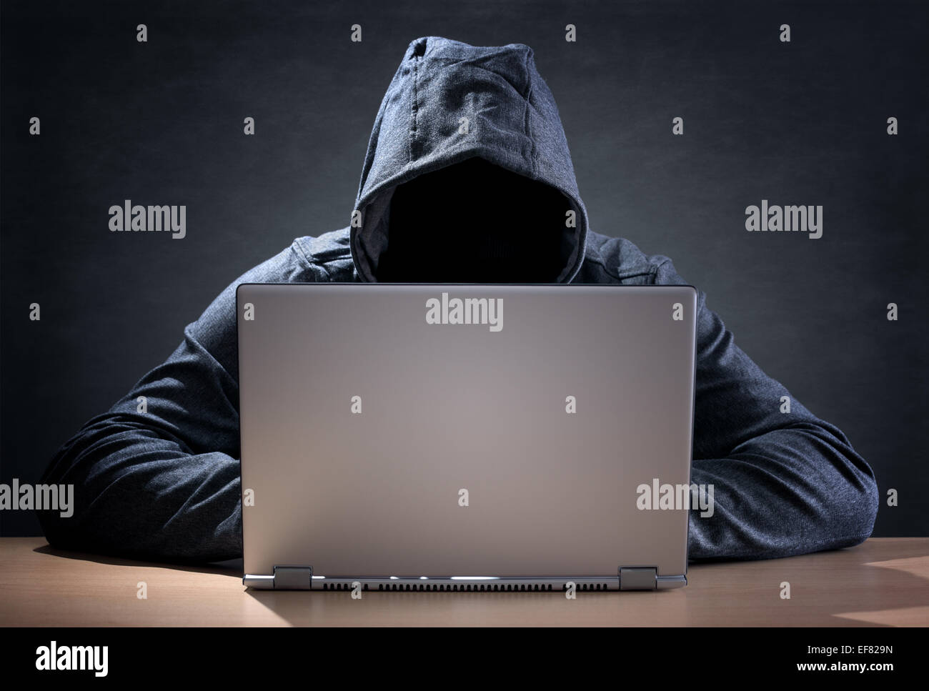 Computer hacker stealing data from a laptop Stock Photo