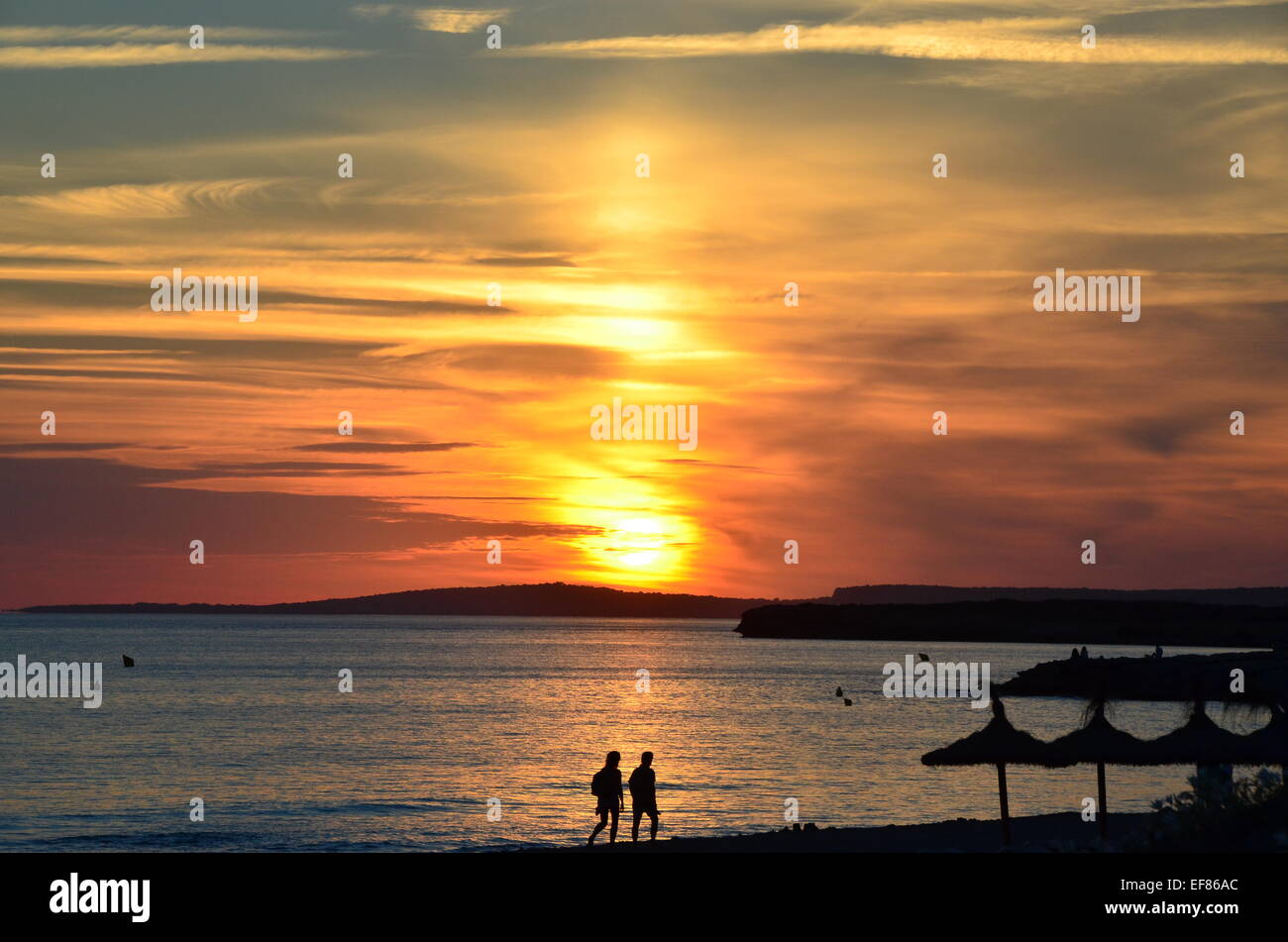 View of the sun setting from the beach at Santo Thomas, Menorca, Balearic Islands, Spain Stock Photo