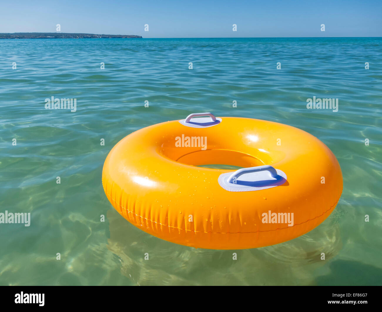 Orange rubber ring floating empty in the sea Stock Photo