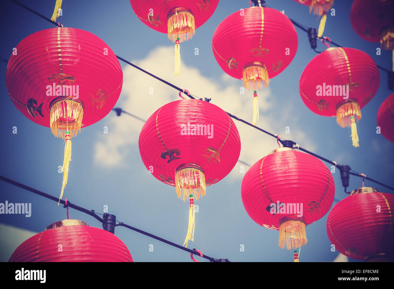 Retro filtered chinese red paper lanterns against blue sky. Stock Photo