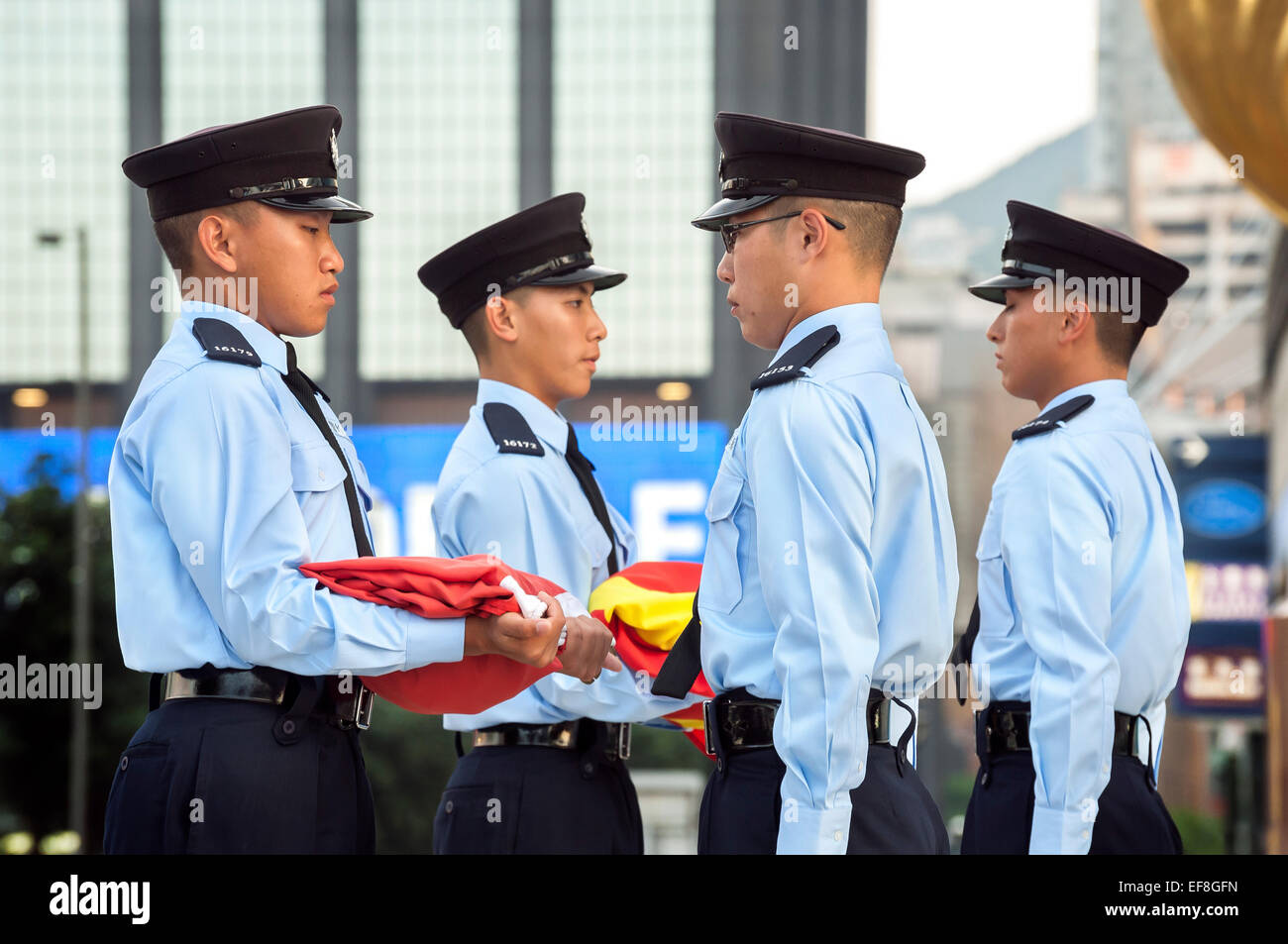 Members of the Hong Kong Police Force carry out the daily flag lowering ceremony at Hong Kong's Golden Bauhinia Square Stock Photo