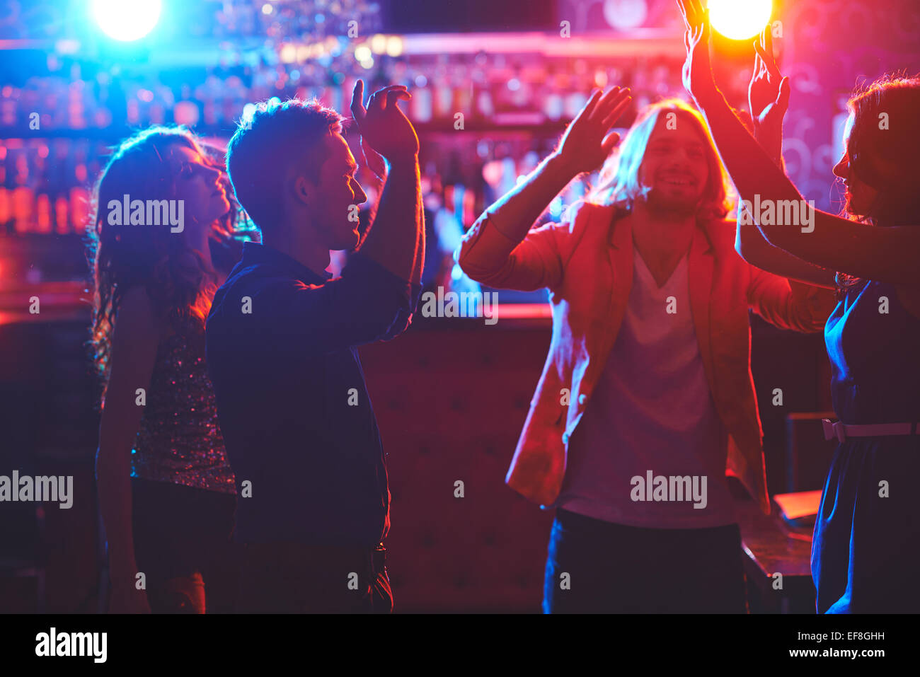Portrait of happy friends dancing by the bar counter Stock Photo - Alamy