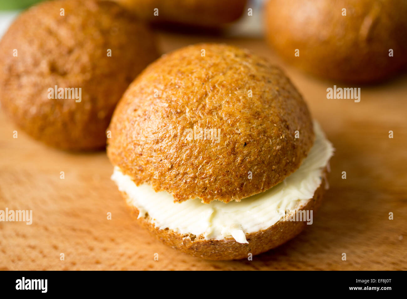 Tasty bun with butter or cheese for breakfast Stock Photo - Alamy
