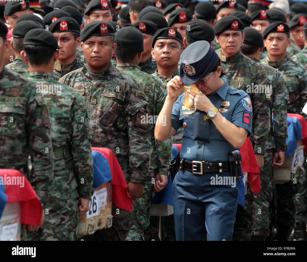 Pasay City, Philippines. 29th Jan, 2015. A policewoman weeps as she walks past the caskets carrying the fallen members of the Philippine National Police Special Action Force (PNP-SAF) at the Villamor Air Base in Pasay City, the Philippines, Jan. 29, 2015. Forty-four members of the PNP-SAF were killed allegedly by Moro Islamic Liberation Front and Bangsamoro Islamic Freedom Fighters members on Jan. 25 in Mamasapano, Maguindanao. Credit:  Rouelle Umali/Xinhua/Alamy Live News Stock Photo