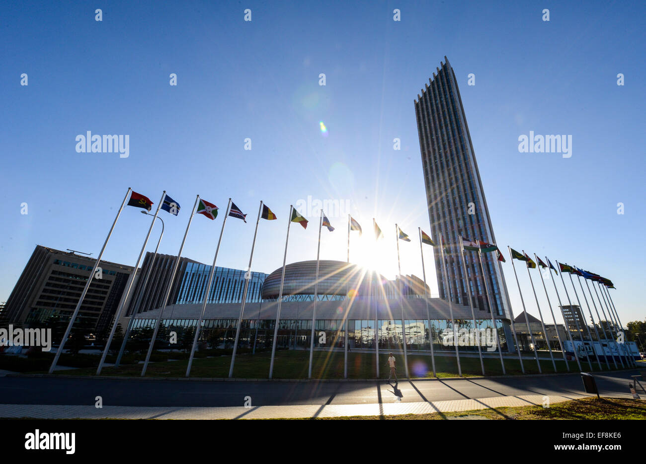 Addis Ababa, Jan. 28. 30th Jan, 2015. A man walks pass the flagpoles outside the African Union (AU) Headquarters in Addis Ababa, capital of Ethiopia, on Jan. 28, 2014. The 24th AU Summit is scheduled to open here on Jan. 30, 2015. © Zhai Jianlan/Xinhua/Alamy Live News Stock Photo