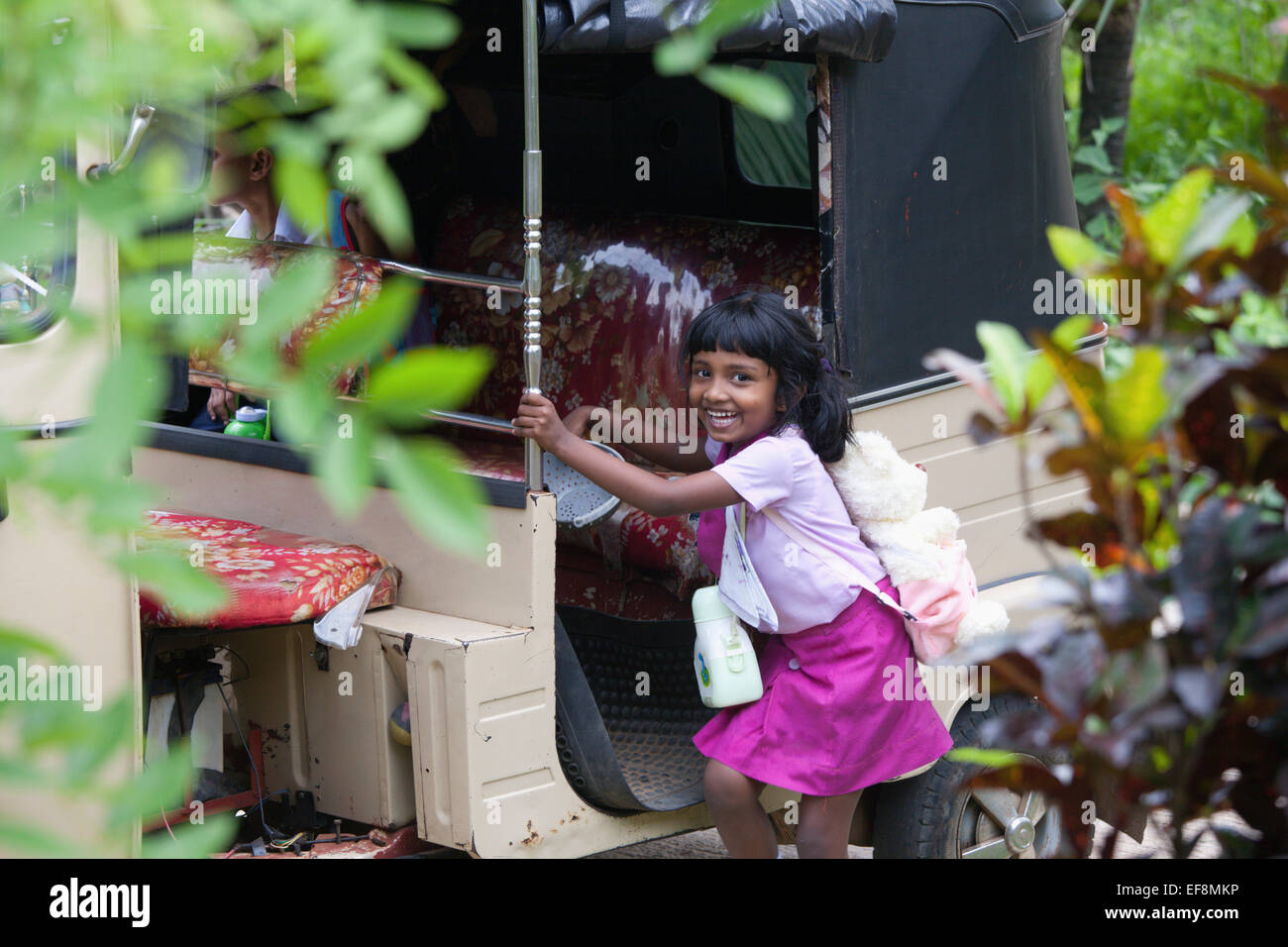 SRI LANKAN SCHOOL CHILD GETTING IN TO A TUK TUK Stock Photo